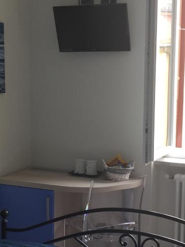 a room with a table with a tv on the wall at La Rosa Dei Venti in Monterosso al Mare