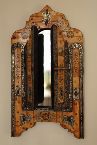 a mirror with a wooden frame hanging on a wall at Aux Truffes de Combecave in Mauroux
