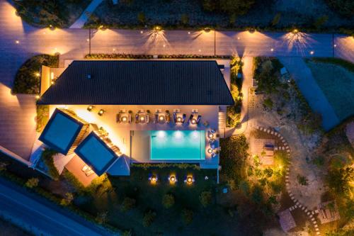 an overhead view of a house with a swimming pool at night at Floria Glamping Garden in Labin