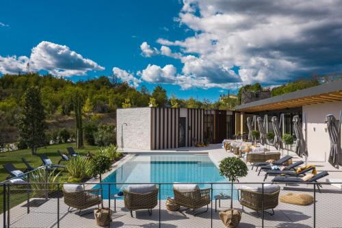 eine Terrasse mit Stühlen und einem Pool in der Unterkunft Floria Glamping Garden in Labin