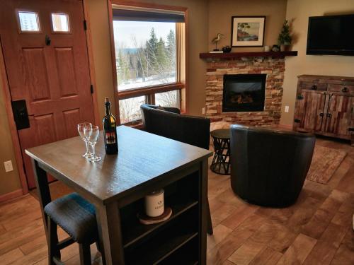 a living room with a table with wine glasses and a fireplace at MyLutsen in Lutsen