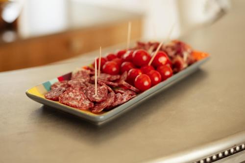 a plate of meat and cherries on a table at Aux Truffes de Combecave in Mauroux