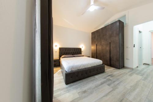 a bedroom with a bed and a large brown headboard at Kalipe House in Bosa