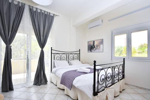 een witte slaapkamer met een zwart bed en een raam bij DiMaGeo Life studio apartment in Chania