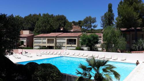 une piscine avec des chaises et une maison dans l'établissement LE VALLON DU ROY, à Sanary-sur-Mer