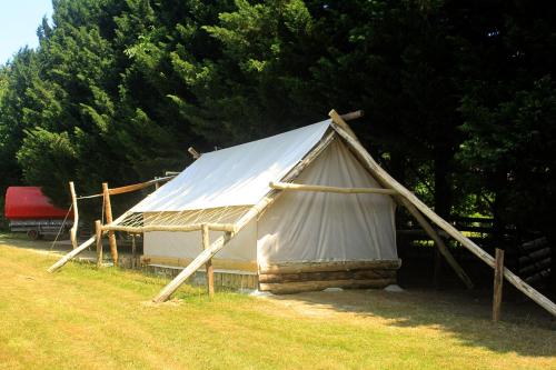 une grande tente blanche installée dans un champ dans l'établissement Tente Trappeur Ada, Au jardin de la Vouivre, à Saint-Vincent-en-Bresse