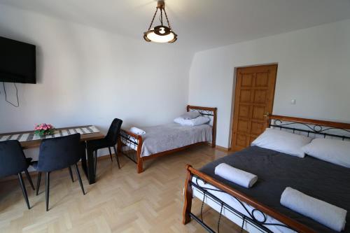 a room with two beds and a table and a dining room at Czar Gór in Krościenko