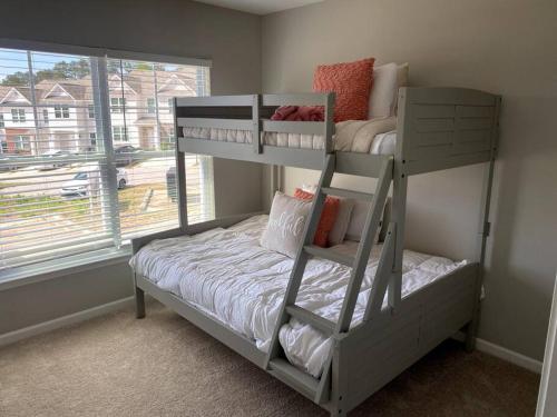 een slaapkamer met 2 stapelbedden en een raam bij Brand NEW HOME mins to airport in Atlanta