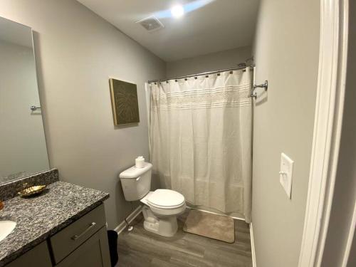 een witte badkamer met een toilet en een douche bij Brand NEW HOME mins to airport in Atlanta