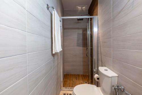 a small bathroom with a toilet and a shower at Navy Blue in Corfu Town