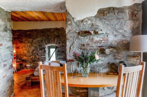 a dining room with a table and a stone wall at Hallgarter Zange in Oestrich-Winkel