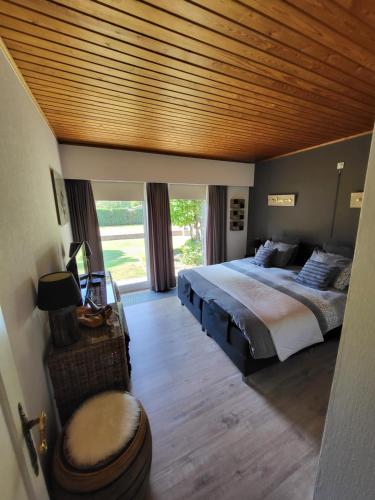 a bedroom with a large bed with a wooden ceiling at villa 2be in Balen