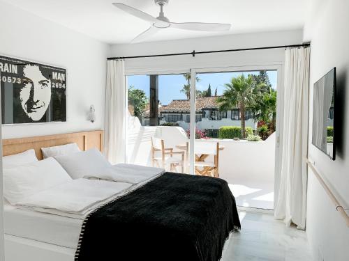 a bedroom with a bed and a view of a patio at Golden Mile Designer Penthouse in Marbella