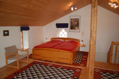 a bedroom with a bed and a chair in a room at Alte Stellmacherei Langenhorn in Langenhorn