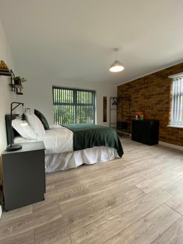 1 dormitorio con 1 cama y suelo de madera en Elegant 4 Bedroom, 5 bathroom House in Northampton by HP Accommodation en Watford