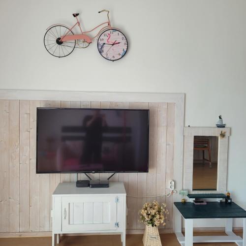 a flat screen tv on a wall with a bike on it at Soulmate Pension in Namhae