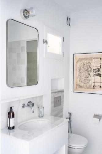a white bathroom with a sink and a mirror at Golden Mile Designer Penthouse in Marbella