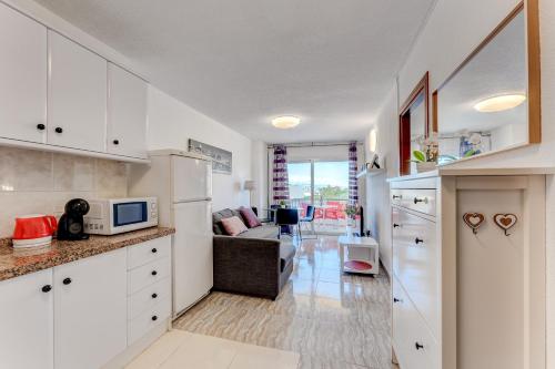 una cucina con armadi bianchi e un soggiorno di Torres del Sol Beach Front Apartment PH06 a Los Cristianos