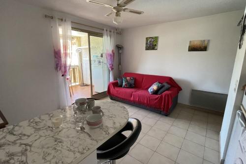 uma sala de estar com um sofá vermelho e uma mesa em T2 with balcony close to the sea em Sainte-Maxime