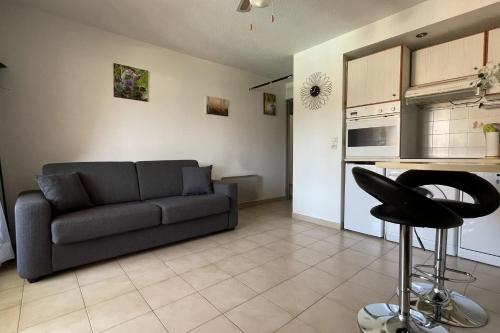 uma sala de estar com um sofá e uma cozinha em T2 with balcony close to the sea em Sainte-Maxime