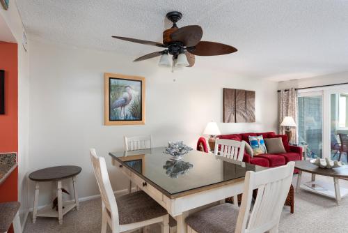 a living room with a table and a ceiling fan at 1317 Pelican Watch Villa in Seabrook Island