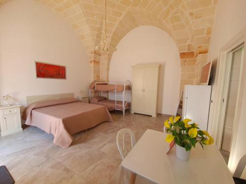 een slaapkamer met een bed en een tafel in een kamer bij Casa Vacanza Fontana in Manduria