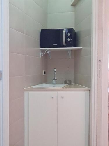 a small kitchen with a sink and a microwave at Casa Vacanza Fontana in Manduria