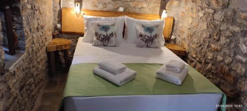 um quarto com uma cama com toalhas em Αυθεντικό πετρινο στην Ναύπακτο em Lepanto