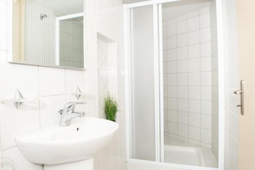 a white bathroom with a sink and a mirror at City Chic Apartments in Limenas