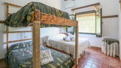 ラ・プエブラ・デ・ロス・インファンテスにあるEl Algarín La Puebla de Los Infantes by Ruralidaysのベッドルーム1室(二段ベッド2台、窓付)が備わります。