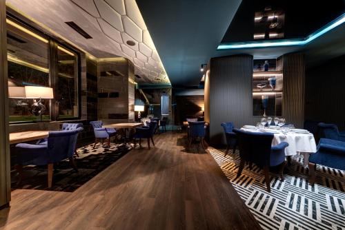 a dining room with tables and blue chairs at Grand Hotel Therme in Banya