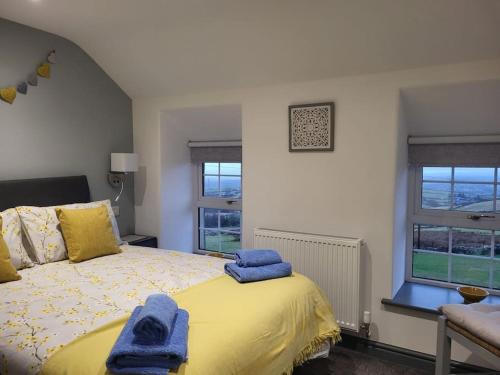 a bedroom with a bed with two towels on it at Amazing coastal & sunset views in Eryri (Snowdonia) in Llanllyfni