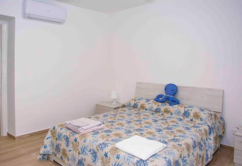 a bedroom with a bed with a comforter and towels at U Fundu du Cialli in Lavagna