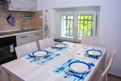 a kitchen with a table with plates and glasses on it at U Fundu du Cialli in Lavagna