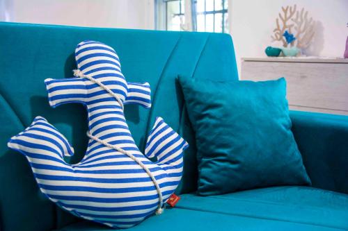 a blue couch with two striped pillows on it at U Fundu du Cialli in Lavagna