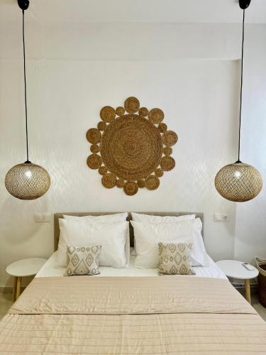 a bedroom with a bed with two lights above it at Mylos Ηome in Ierapetra