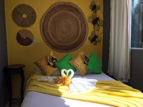 a bed with a bunch of pillows on it at Pousada Alto Astral in Olinda