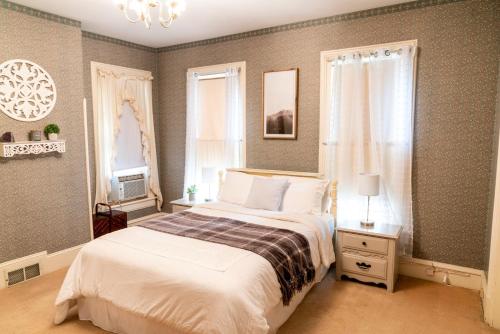 - une chambre avec un grand lit et un lustre dans l'établissement CHARMING EXECUTIVE VICTORIAN MANSION w/ FREE PARKING - near Bucknell, à Milton