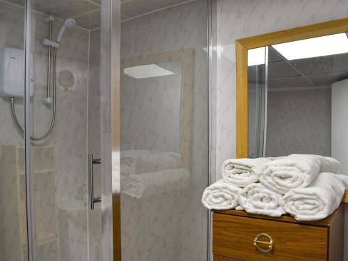 a bathroom with a shower and a pile of towels at Apartment 786 At The Granville in Blackpool