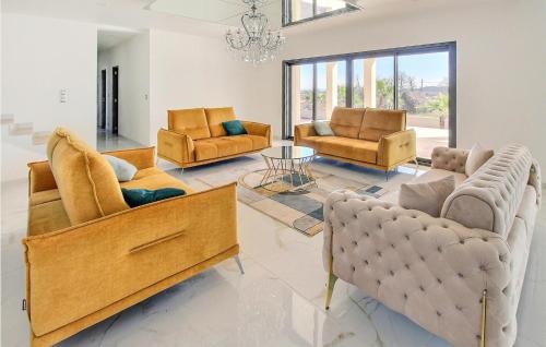 ein Wohnzimmer mit Sofas, Stühlen und einem Kronleuchter in der Unterkunft Amazing Home In Pont Saint Esprit in Pont-Saint-Esprit