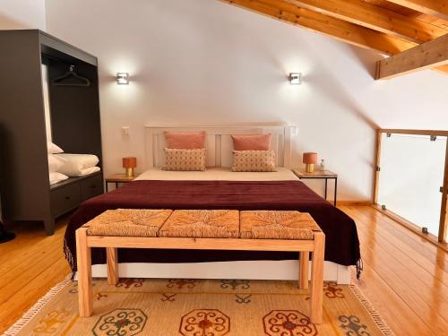 a bedroom with a large bed with a wooden floor at Quinta das Carpas in Tavira