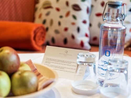 a bowl of apples and a bottle of water on a table at Der Verdinser Hof in Schenna