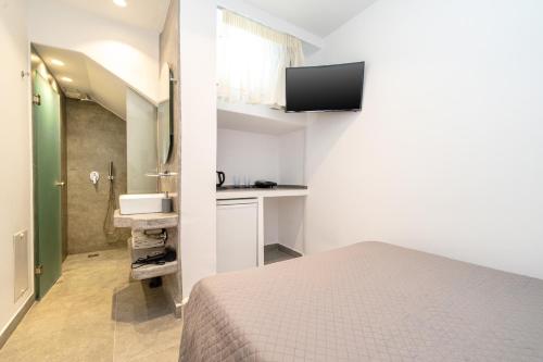 mały pokój z łóżkiem i umywalką w obiekcie Anius Apartments w mieście Mykonos