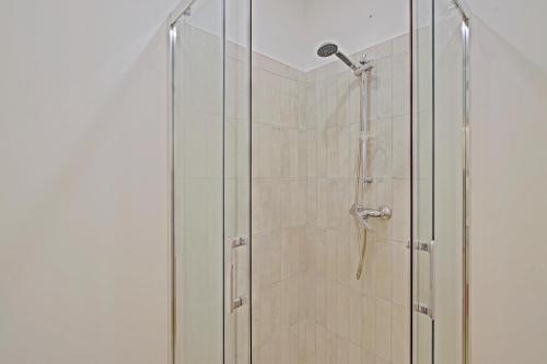 une douche avec une porte vitrée dans une salle de bain dans l'établissement Studio calme et moderne à 300m de la plage -1-, à Canet