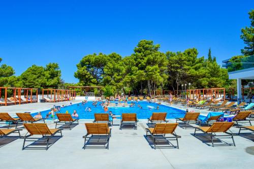 een groot zwembad met stoelen en mensen erin bij Croatia Camp SEA VIEW in Vodice