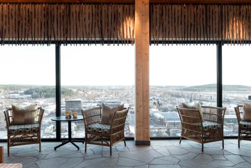 a room with chairs and a table and large windows at The Wood Hotel by Elite in Skellefteå