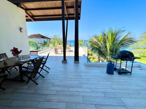 a patio with a table and chairs and a grill at Beach Penthouse BELMARE in Belle Mare