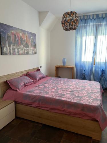 una camera da letto con un grande letto e un piumone rosa di Giramondo a Senigallia