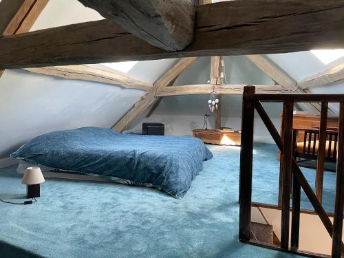 une chambre avec un lit dans un grenier dans l'établissement Villa Fontaine avec piscine intérieur chauffée-Maison de campagne Familiale -idéal Vacances ou Séjour Professionnel -3 chambres-Bureau séparé -Lit Bébé - Parking Facile & Gratuit, à Fontaine-la-Gaillarde