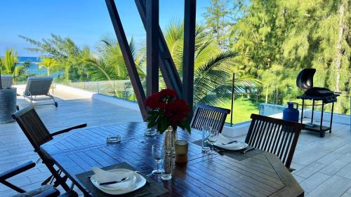 a wooden table with a vase of flowers on a patio at Beach Penthouse BELMARE in Belle Mare